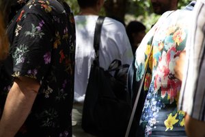 Picture of persons in flowery dresses standing near by each other