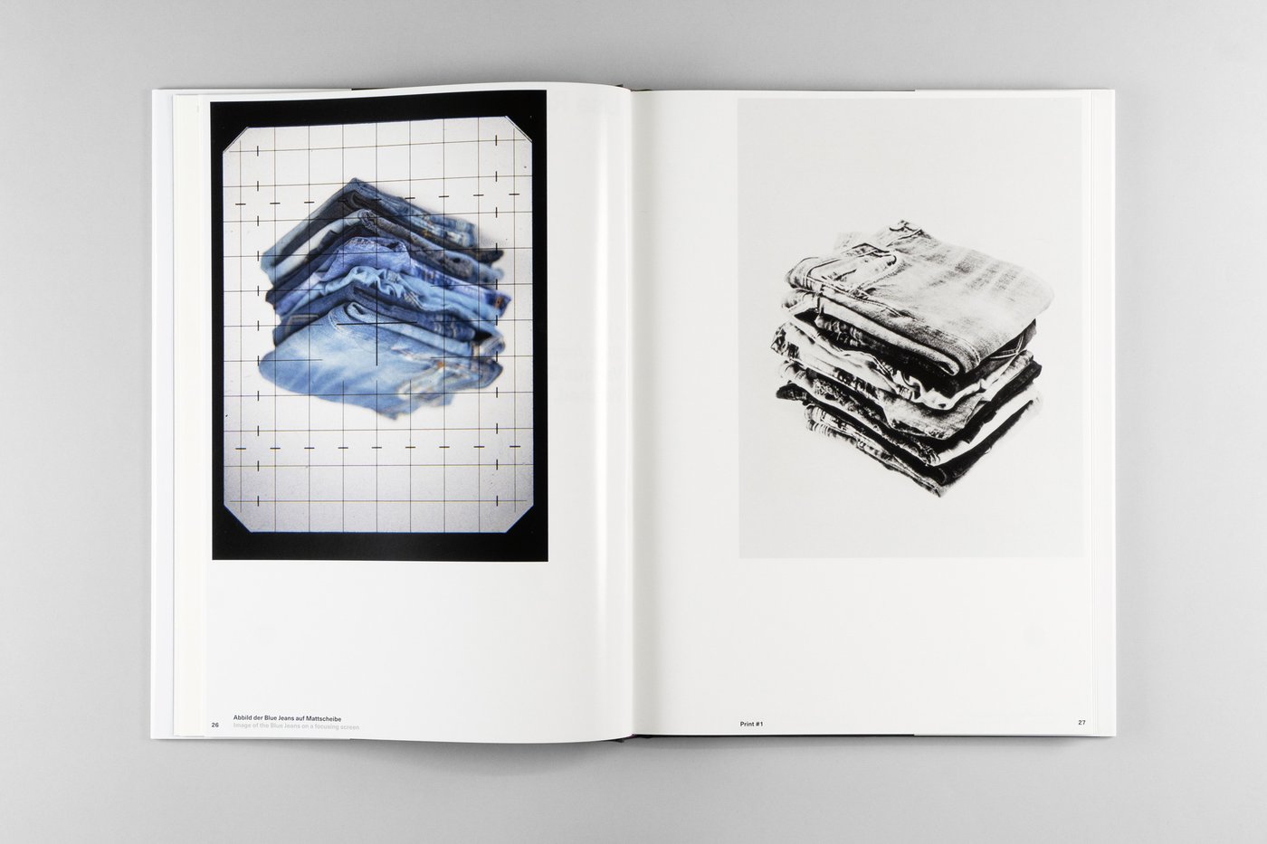 Double page from the book Photography as Motif with a photo spread by Lisa Rastl showing pictures of folded and stacked pairs of jeans, on the left in color and rotated by 180 degrees, on the right in grayscale.