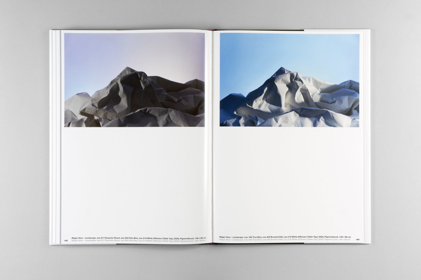 Double page from the book Photography as Motif with the picture contribution by Caroline Heider with photos of a mountain range made of paper with different sky colors in the background.